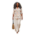 Modelo con blusa Ibravacr de estampado floral, escote en V y pantalones de pierna ancha color crema con bolso