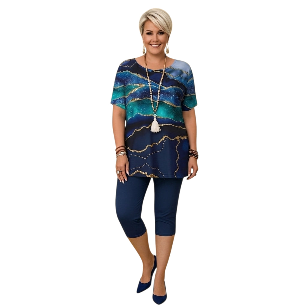 Modelo con conjunto Ibravacr de blusa estampada abstracta azul y dorada con pantalones capri azul marino