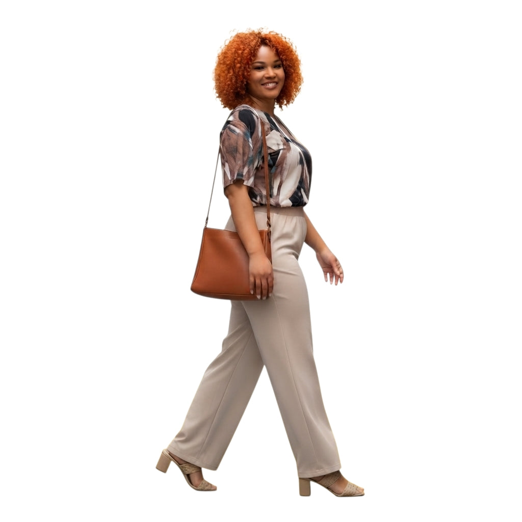 Modelo con conjunto Ibravacr de blusa estampada abstracta y pantalón recto beige con bolso de hombro color cuero