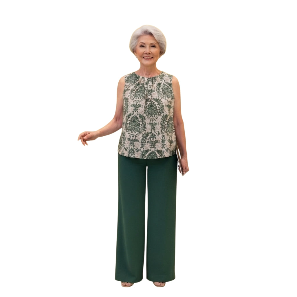 Mujer madura vistiendo conjunto Ibravacr de blusa sin mangas con estampado botánico y pantalones verde bosque anchos.