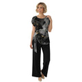Modelo vistiendo conjunto Ibravacr de blusa con estampado de mármol gris y negro y pantalón negro de pierna ancha.