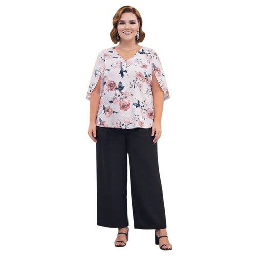 Modelo de talla grande vistiendo conjunto Ibravacr de blusa floral con mangas abiertas y pantalón negro de corte recto.