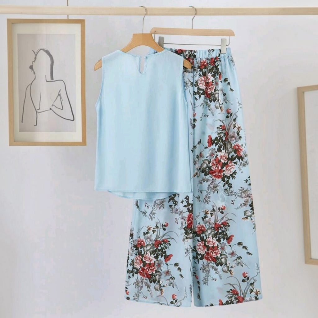 Conjunto Ibravacr de blusa azul cielo sin mangas y pantalón de pierna ancha con estampado floral en tonos rojos.
