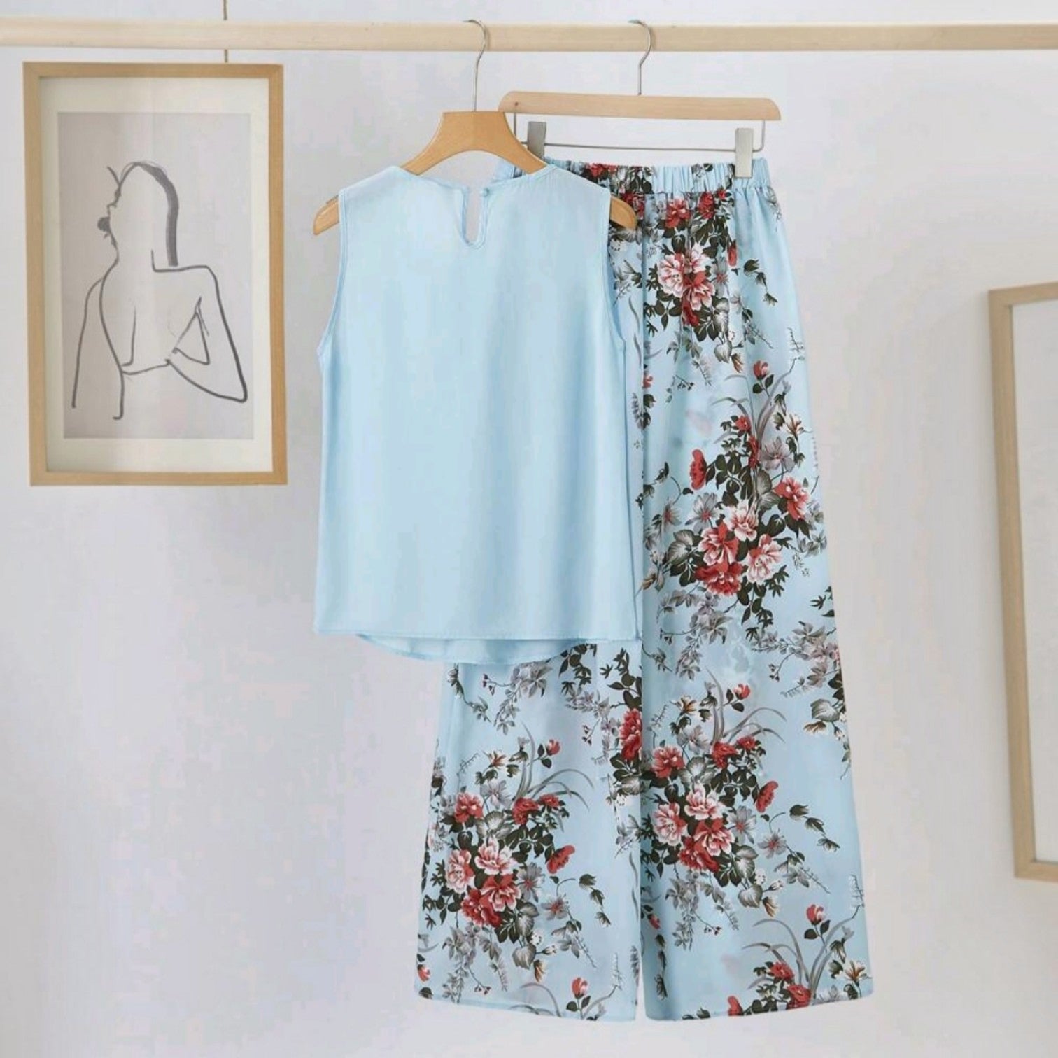 Conjunto Ibravacr de blusa azul cielo sin mangas y pantalón de pierna ancha con estampado floral en tonos rojos.