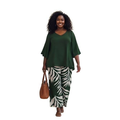 Modelo sonriente vistiendo conjunto Ibravacr de blusa verde con mangas acampanadas y pantalones de pierna ancha botánicos