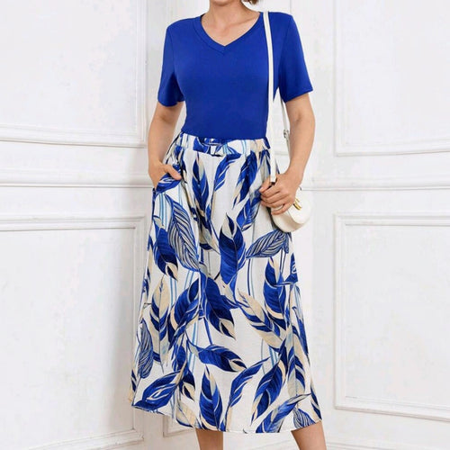 Conjunto de dos piezas Ibravacr con blusa azul de cuello en V y falda midi fluida con estampado botánico y bolsillos.
