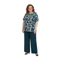 Modelo sonriente vistiendo conjunto Ibravacr de dos piezas con blusa estampada botánica azul y pantalón azul petróleo.