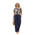 Mujer sonriente vistiendo conjunto Ibravacr de blusa estampada abstracta y pantalón azul marino holgado con bolsillos.