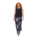 Modelo de pelo rojo vistiendo conjunto Ibravacr de blusa negra sin mangas y pantalón holgado con estampado floral.