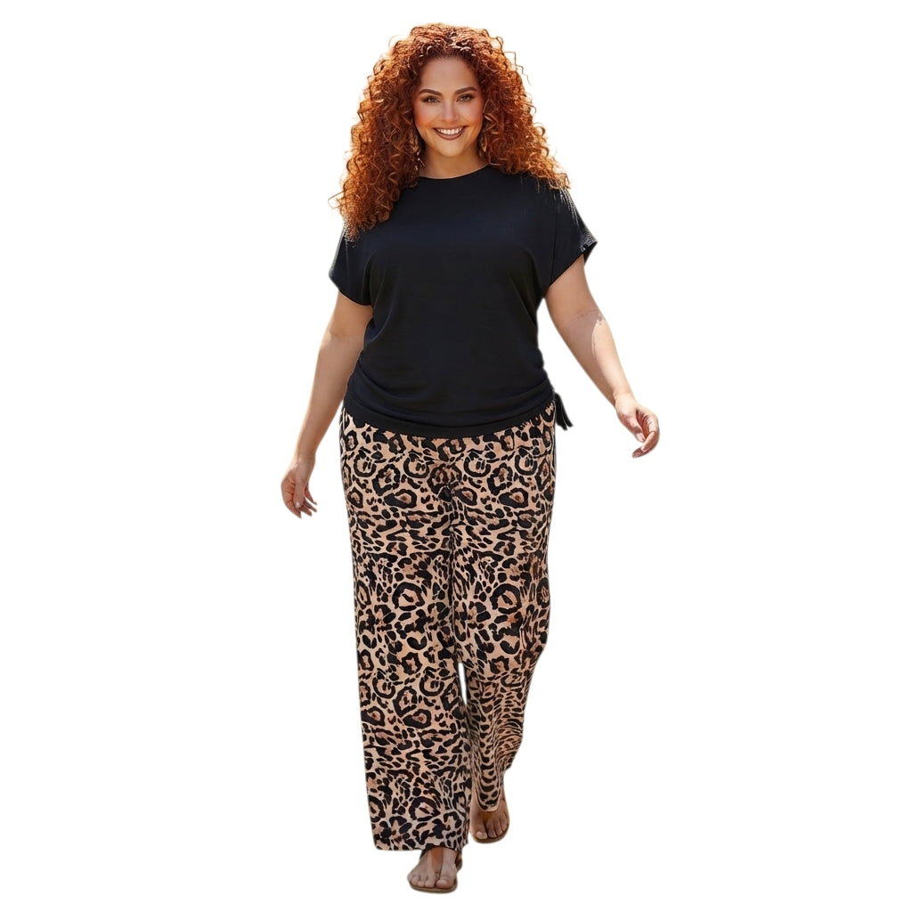 Modelo con conjunto Ibravacr de dos piezas: blusa negra con cordones laterales y pantalones de pierna ancha leopardo.