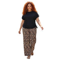 Modelo con conjunto Ibravacr de dos piezas: blusa negra con cordones laterales y pantalones de pierna ancha leopardo.