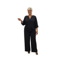 Modelo con conjunto Ibravacr de dos piezas negro, blusa con escote en V y pantalón de pierna ancha fluido