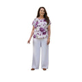 Mujer vistiendo conjunto Ibravacr de blusa floral violeta y pantalón de vestir blanco de corte recto