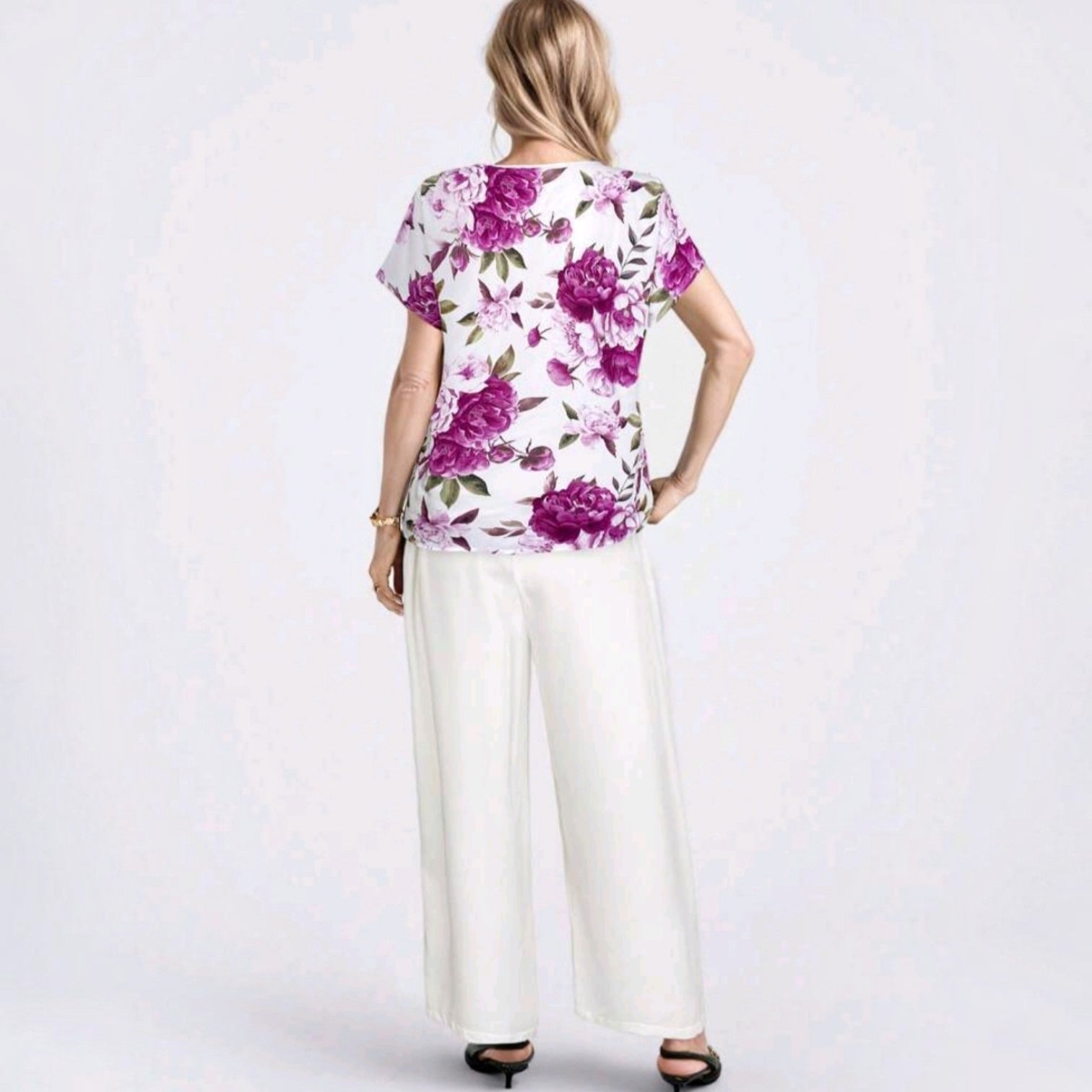 Vista trasera del conjunto Ibravacr con blusa de estampado floral violeta y pantalones blancos de corte recto.