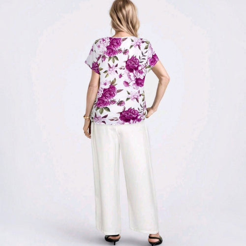 Vista trasera del conjunto Ibravacr con blusa de estampado floral violeta y pantalones blancos de corte recto.