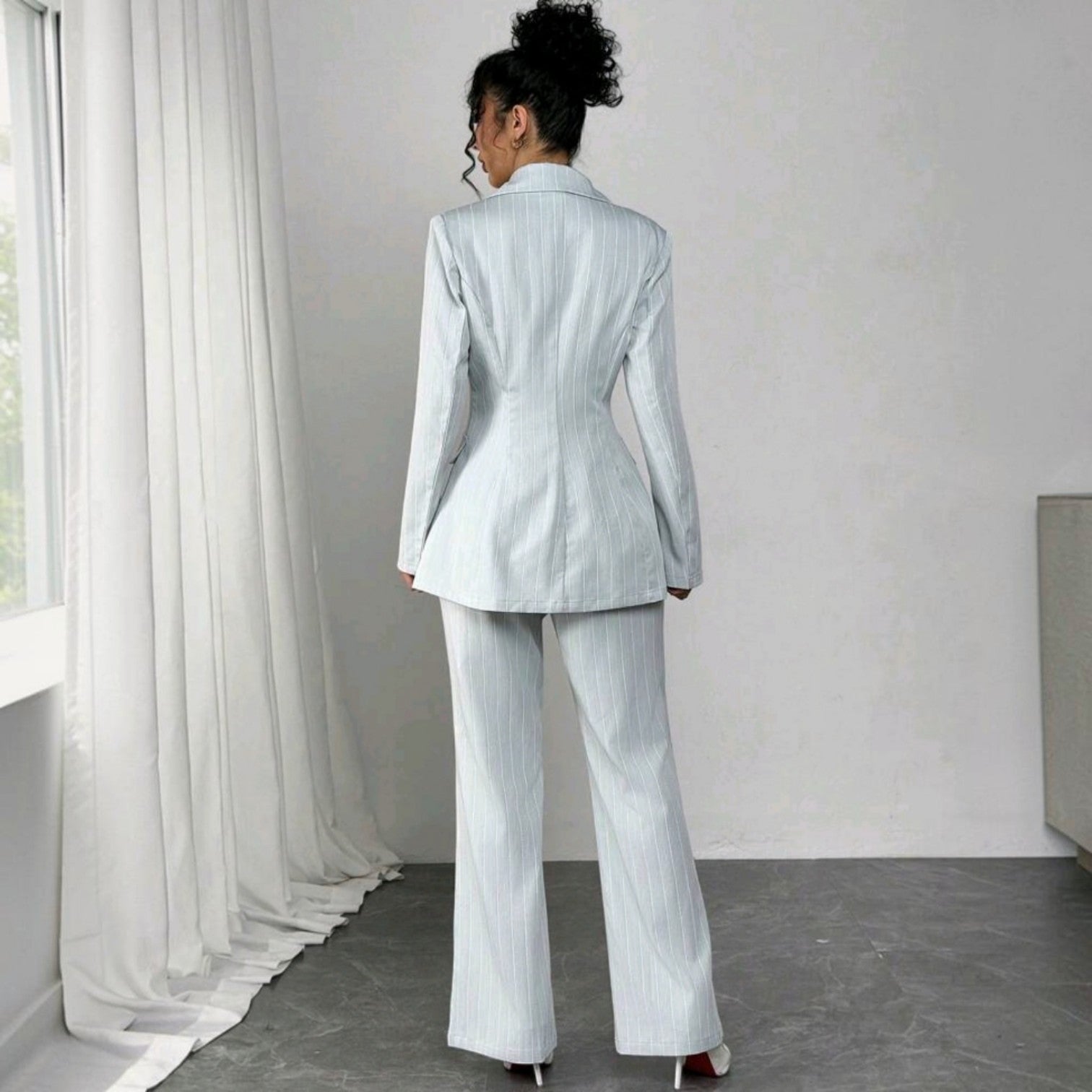 Vista trasera de mujer vistiendo conjunto formal Ibravacr de tres piezas azul claro con rayas verticales
