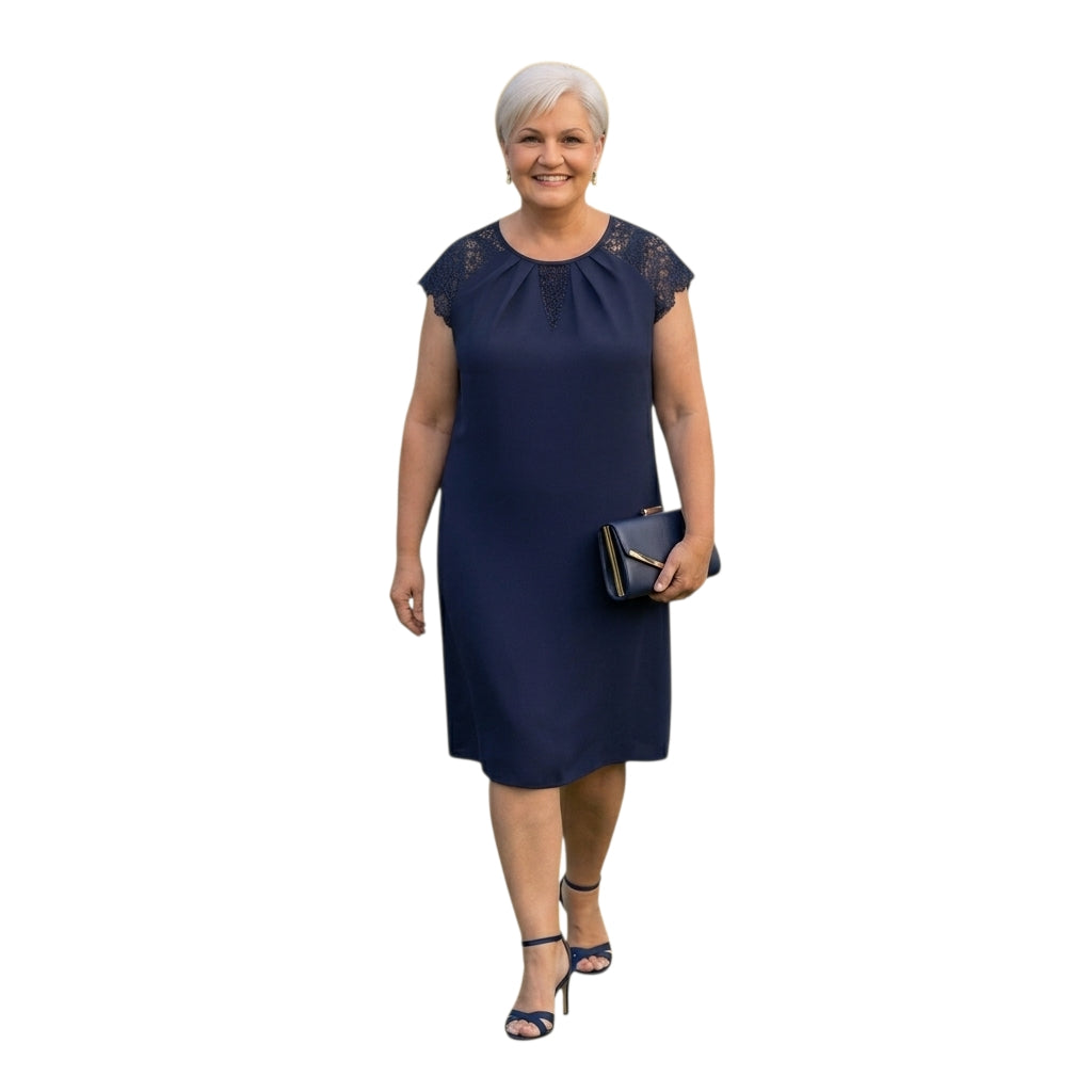 Mujer madura sonriente vistiendo un elegante vestido azul marino Ibravacr con mangas de encaje y bolso a juego