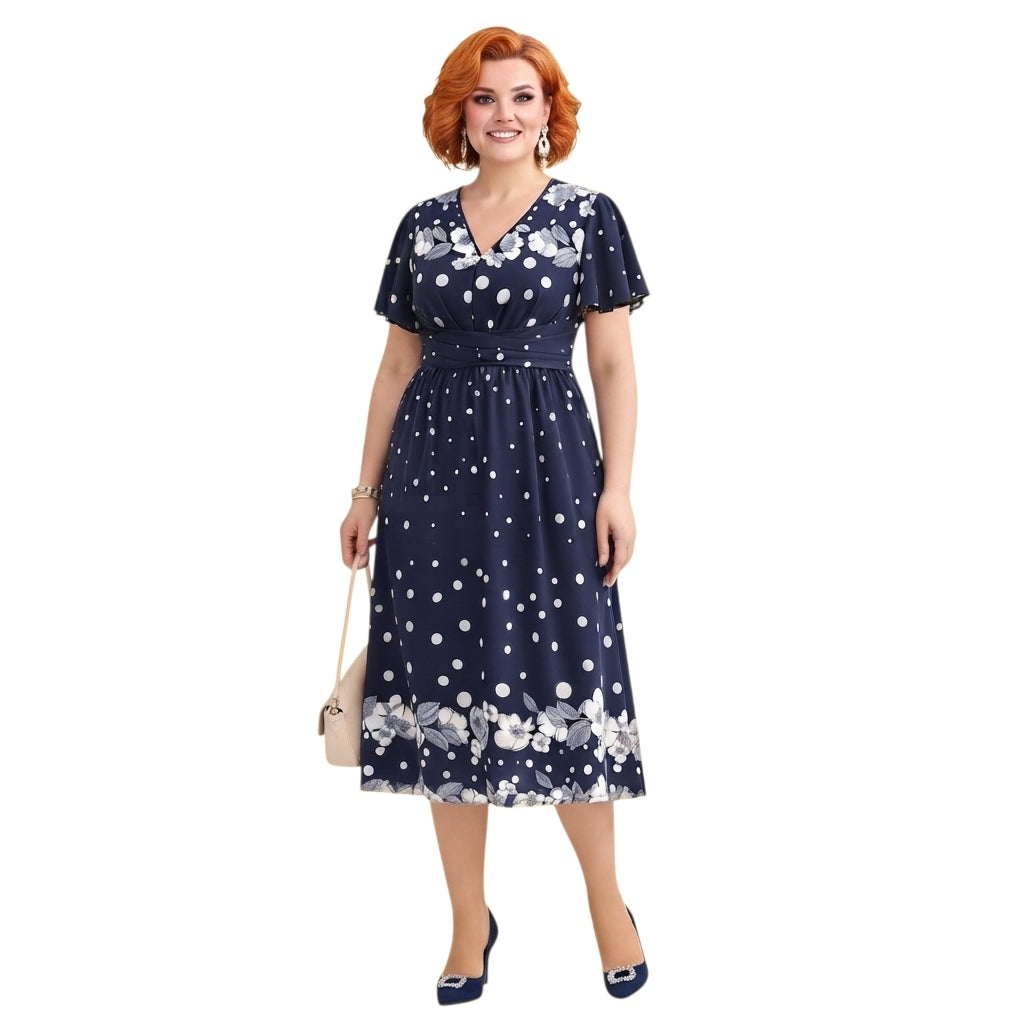 Modelo con vestido midi Ibravacr azul marino de lunares y flores, escote en V y mangas cortas con vuelo