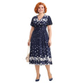 Modelo con vestido midi Ibravacr azul marino de lunares y flores, escote en V y mangas cortas con vuelo
