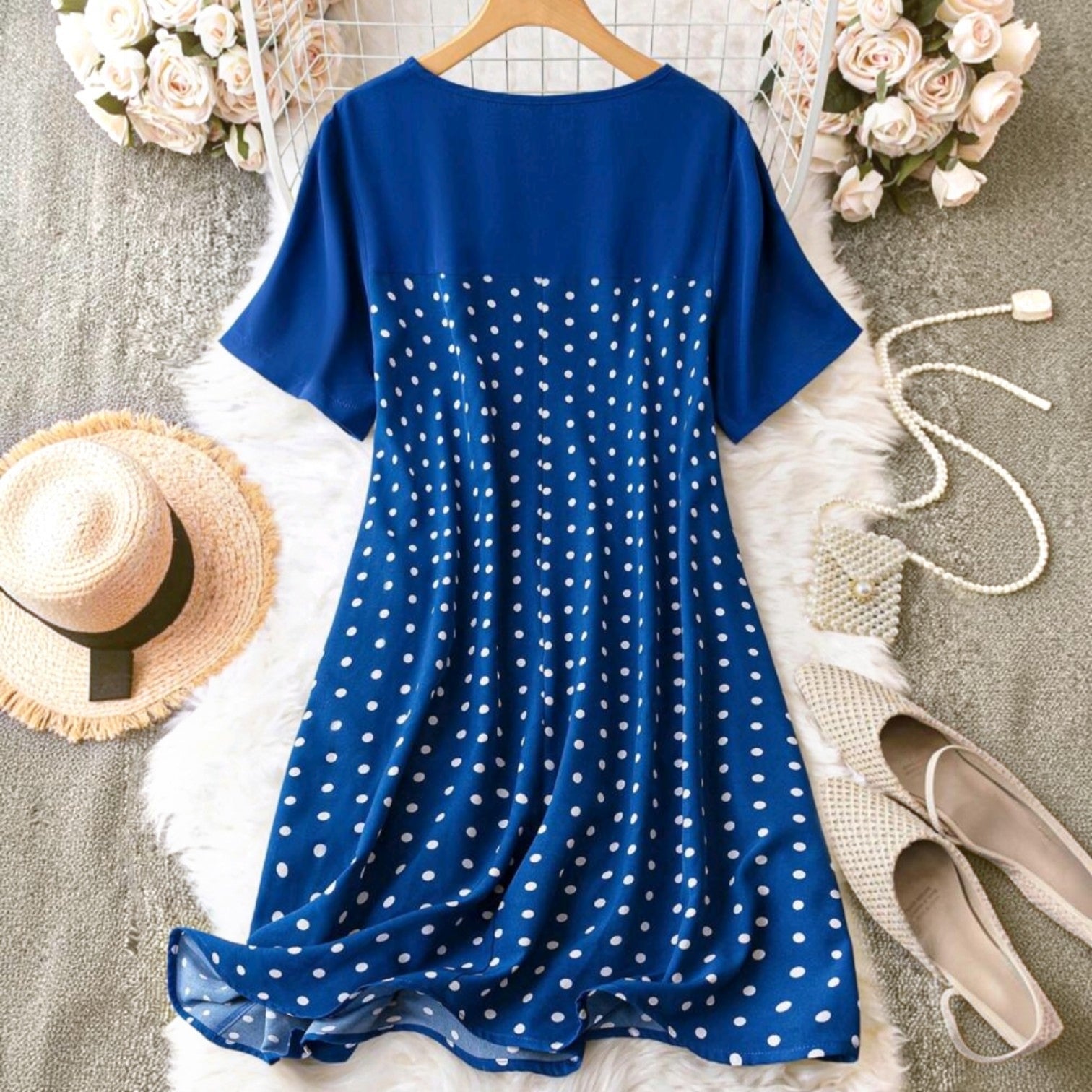 Vestido midi Ibravacr azul con lunares blancos, manga corta y cuello redondo sobre una alfombra de piel sintética.