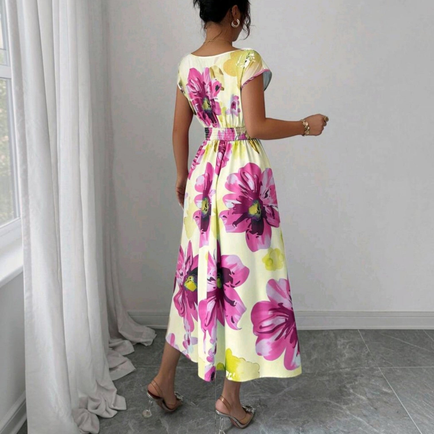 Vista trasera de un vestido midi Ibravacr con estampado floral fucsia y amarillo, cintura elástica y falda fluida.