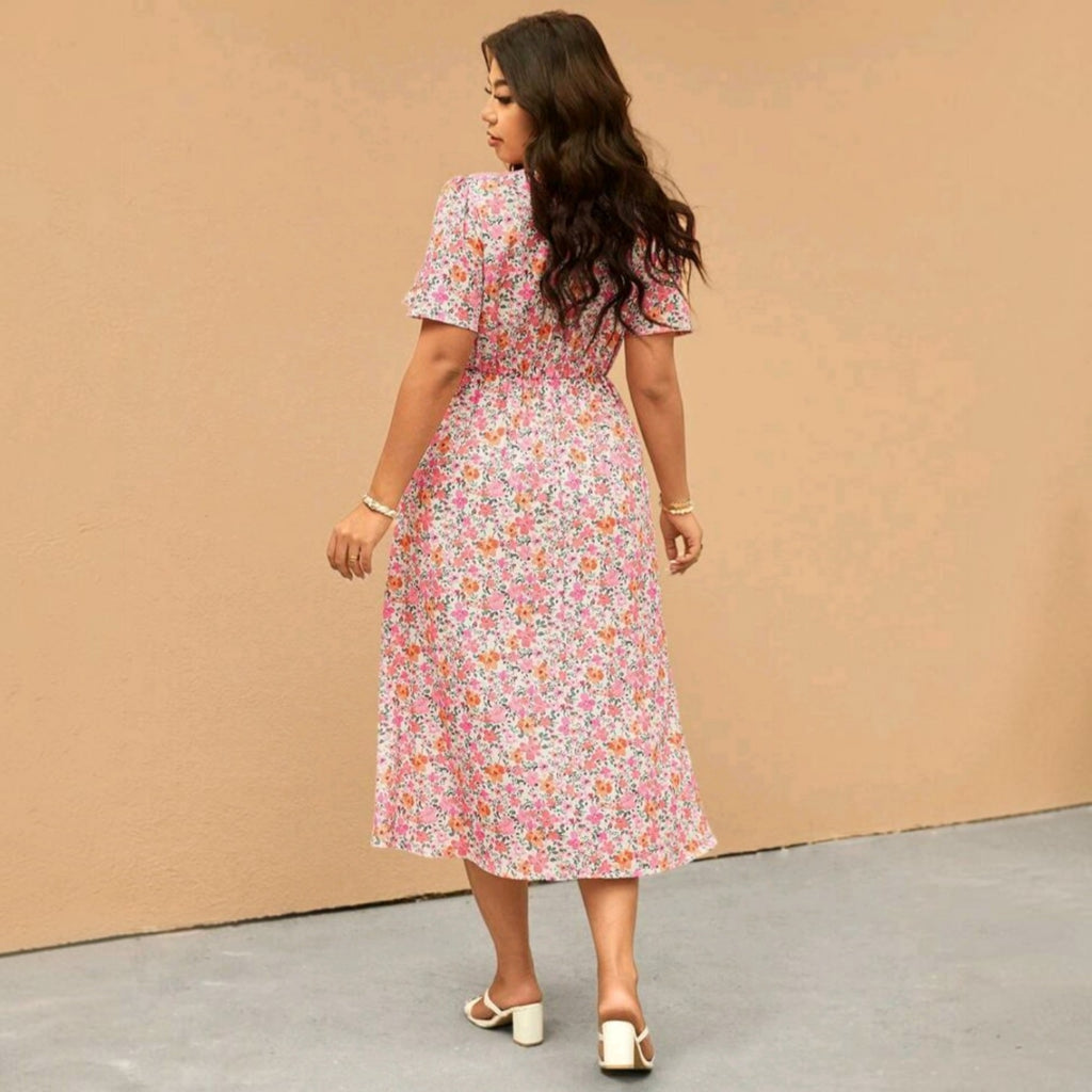 Vista trasera de una modelo usando un vestido midi floral Ibravacr con falda fluida y mangas cortas en tonos suaves.