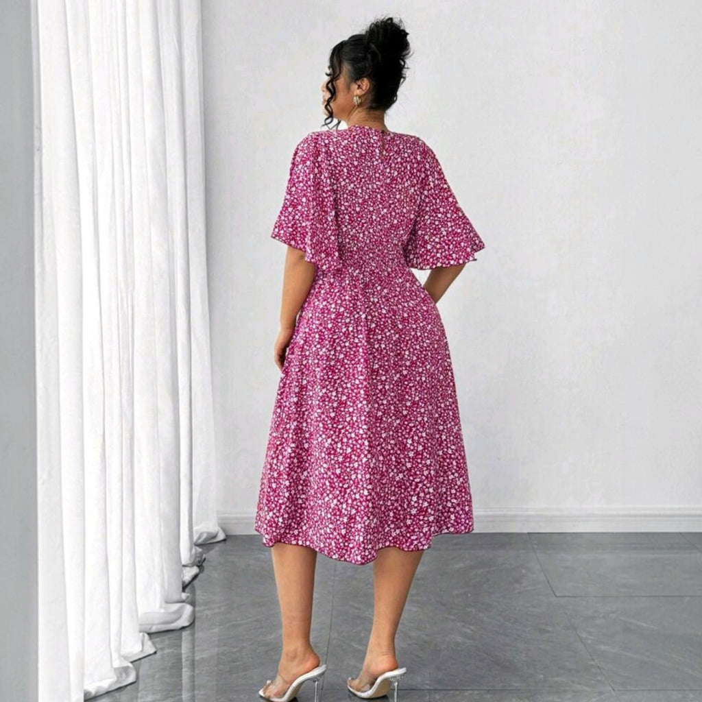 Vista trasera de modelo vistiendo vestido midi Ibravacr fucsia con estampado floral, mangas acampanadas y cintura nido