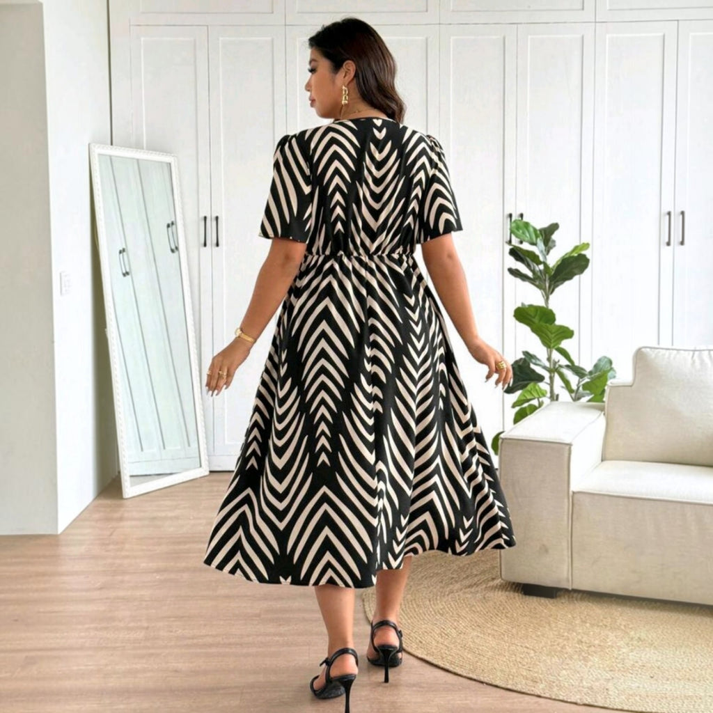 Mujer vistiendo vestido midi Ibravacr con estampado geométrico blanco y negro, mangas cortas y falda fluida.
