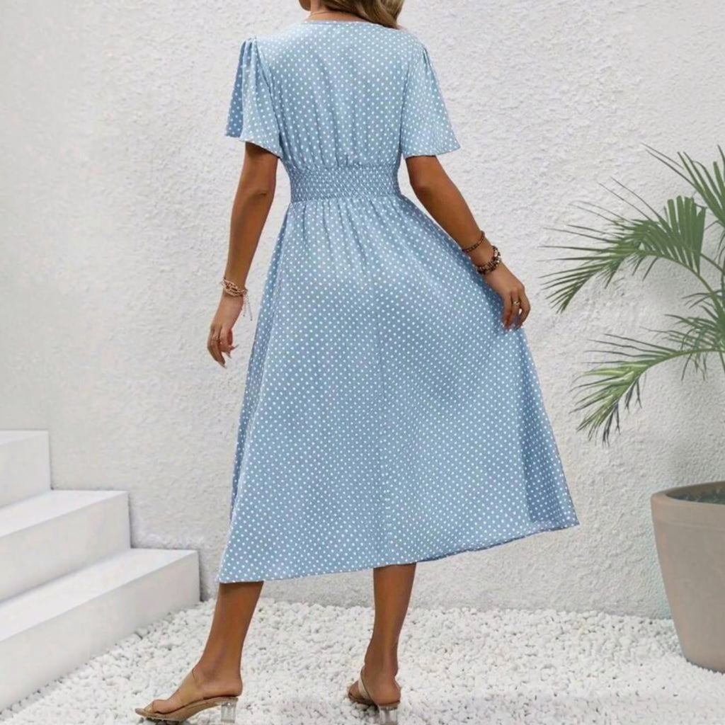 Vista trasera de un vestido midi Ibravacr azul celeste con lunares blancos, escote en V y cintura elástica fruncida.