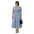 Modelo sonriente vistiendo vestido midi Ibravacr azul celeste con lunares blancos, escote en V y cintura elástica.