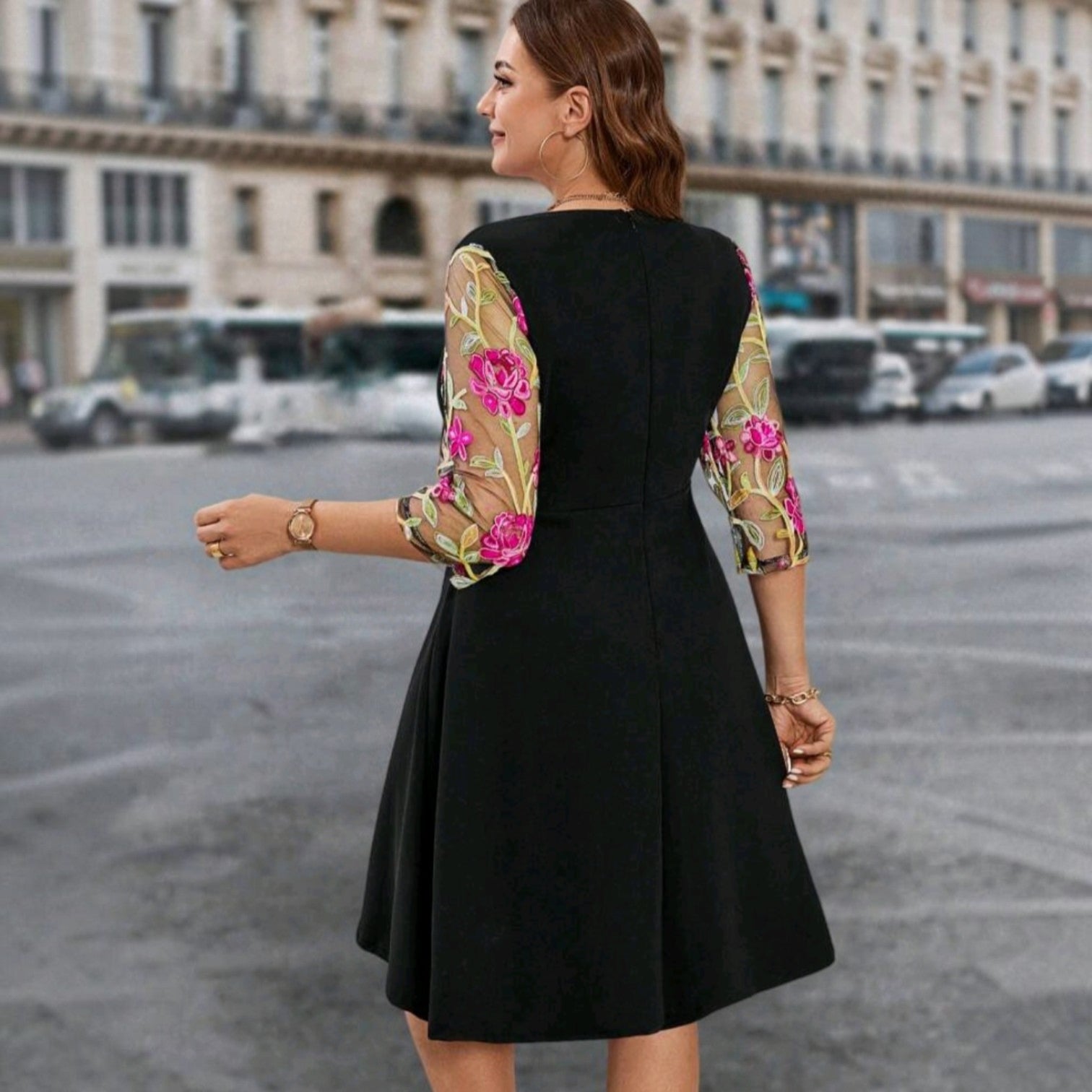 Vestido midi negro Ibravacr con mangas de malla transparente y bordado floral rosa y verde en un entorno urbano