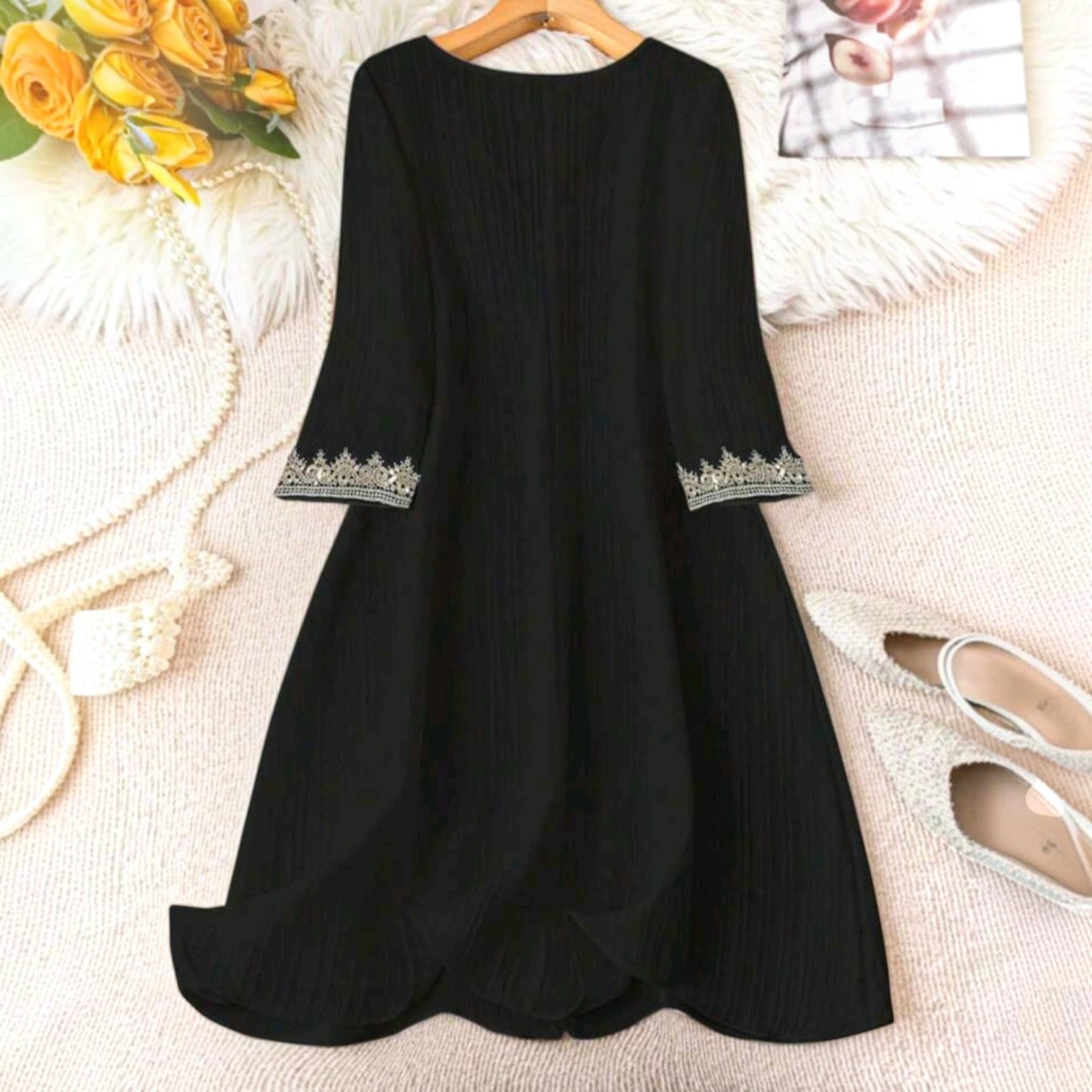 Vestido midi negro Ibravacr con textura plisada, mangas tres cuartos y delicados bordados en los puños.