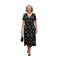 Mujer madura vistiendo un vestido midi negro Ibravacr con estampado geométrico y floral, escote en V y mangas cortas.