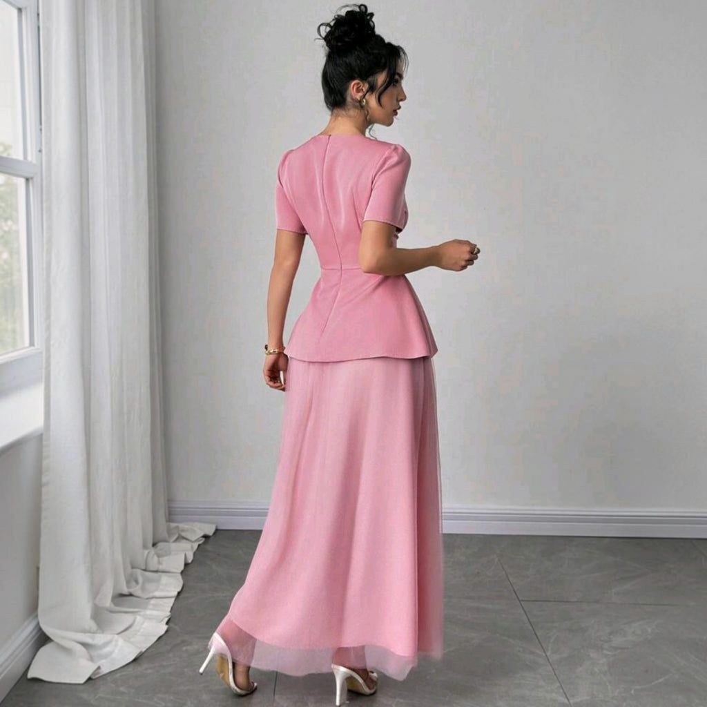 Vista trasera de un vestido midi Ibravacr rosa empolvado con detalle peplum, falda de tul y mangas cortas.