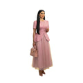 Modelo luciendo vestido midi Ibravacr rosa empolvado con peplum, botones frontales y falda de tul vaporosa.