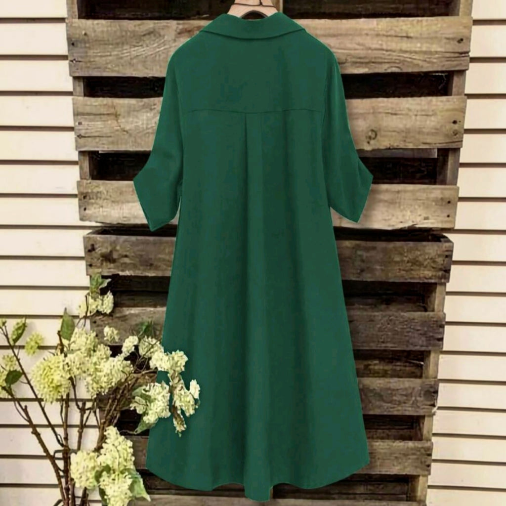 Vestido midi Ibravacr verde bosque con cuello camisero y corte fluido, vista trasera sobre fondo de madera rústica.