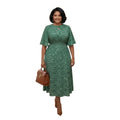 Mujer sonriente vistiendo un vestido midi verde Ibravacr con estampado floral, mangas acampanadas y bolso marrón
